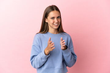 Young woman over isolated pink background applauding after presentation in a conference