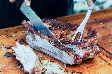 man cutting the argentine asado