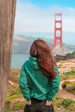 Amzing view of a young woman and Golden Gate Bridge in San Francisco on a sunny day
