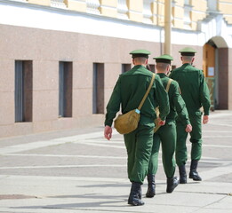 Three Russian soldiers walk in formation along the city street, Palace Square, St. Petersburg,...
