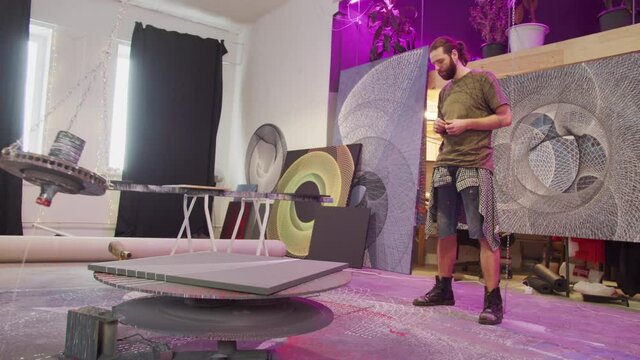 A painter is creating a picture with a special equipment