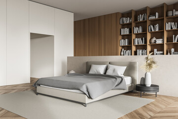 Light bedroom interior, grey bed with linens and coffee table, bookshelf on background