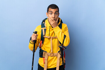 African American man with backpack and trekking poles over isolated background surprised and shocked while looking right