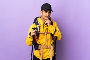 African American man with backpack and trekking poles over isolated background thinking an idea while looking up