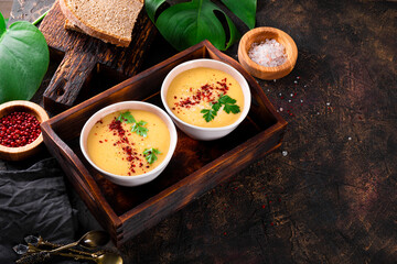 Two bowls of split pea puree soup on the table free space for text