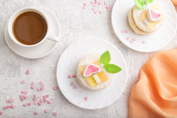 Decorated cake with milk and coconut cream with cup of coffee on a gray concrete background. top view.