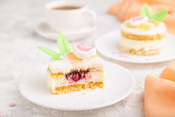 Decorated cake with milk and coconut cream with cup of coffee on a gray concrete background. Side view, selective focus.