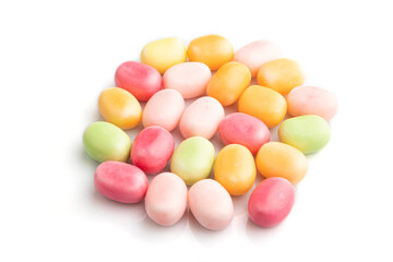Heap of multicolored caramel candies isolated on white background, side view.