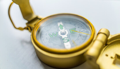 Banner of golden compass isolated, shallow DOF, focus on dial. Compass on a white background. Concept for direction, travel, guidance or assistance.