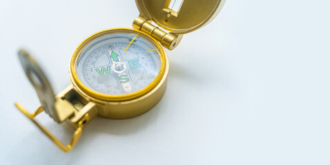 Banner of golden compass isolated, shallow DOF, focus on dial. Compass on a white background. Concept for direction, travel, guidance or assistance.