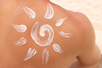 Fototapeta premium Sun shaped sunscreen is applied to male back