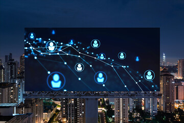 Glowing Social media icons on billboard over night panoramic city view of Kuala Lumpur, Malaysia, Asia. The concept of networking and establishing new connections between people and businesses in KL