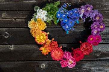Pride flower arrangement, with a rainbow of flowers in a heart shape, with copy space