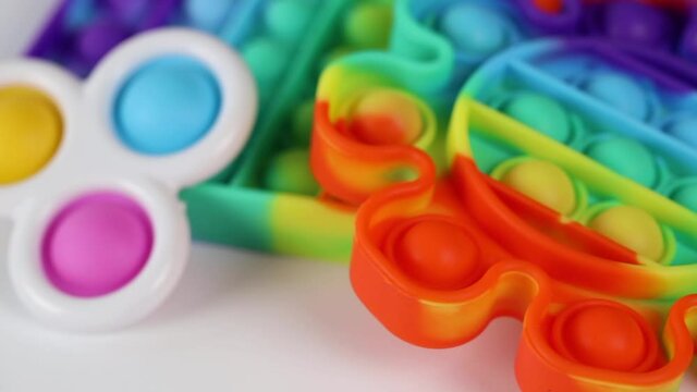 Anti-stress toys pop it, simble dimble, snapperz spinning on white background. Concept trendy entertainment for fidget children, sensory toys for development of fine motor skills, stress relieving.