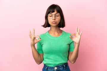 Young mixed race woman isolated on pink background in zen pose