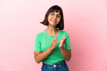 Young mixed race woman isolated on pink background applauding after presentation in a conference