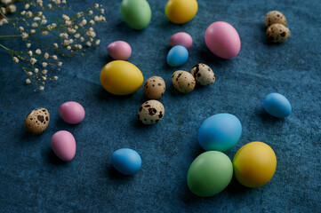 Fototapeta na wymiar Easter eggs and wildflowers on blue background