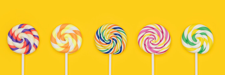 Five Fruit Rainbow Swirl Flat Lollipops in a row banner. Lollipop candy set. Different sugar...