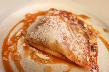 crepes de crema y caramelo polvoreado con azúcar glas