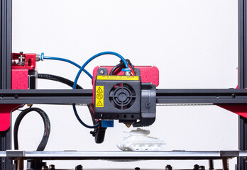 Working 3d printer. Printhead with hotend and fan close-up. Isolated on white background.