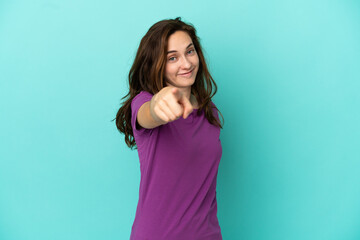Young caucasian woman isolated on blue background pointing front with happy expression