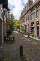 Fototapeta na wymiar narrow cobblestone street with brick buildings in the historic city center of Haarlem