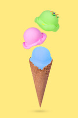 Ice cream cone with  flying colorful ice cream scoops on pastel yellow background.