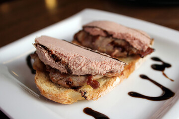 exquisita tostada de solomillo de ternera con foie y sirope en plato blanco