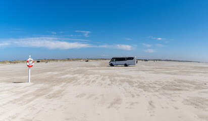 large RV parked on an endless golden sandy beach on the Wadden Sea islands of western Denmark