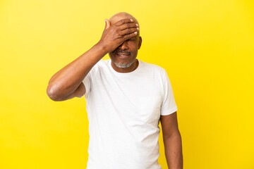 Cuban Senior isolated on yellow background covering eyes by hands. Do not want to see something