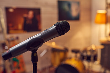 Black microphone against posters of popular modern female musicians