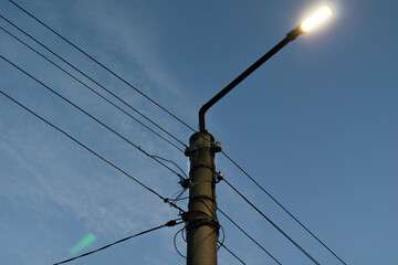 oncrete tower of power lines with lantern against dark sky background