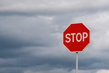 Stop sign against dramatic cloudy sky. Abstract background and texture for design.