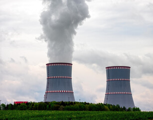Two cooling towers close-up of nuclear power plant against the cloudy dramatic sky in Ostrovets,...