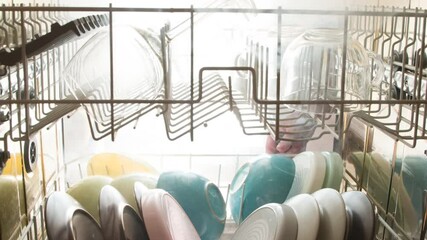 Steam Sterilization of Clean Dishes. View from the dishwasher to the outside. The door opens and clouds of steam burst out, illuminated by a bright light. Filmed at a speed of 120fps