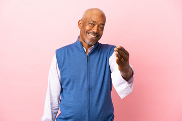 Cuban senior isolated on pink background shaking hands for closing a good deal