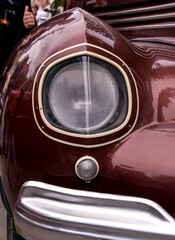 Retro car festival. Retro car headlight. Fragment of the front of a retro car.
