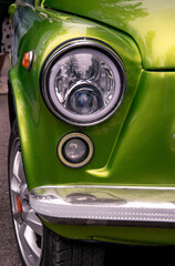 Retro car festival. Retro car headlight. Fragment of the front of a retro car.