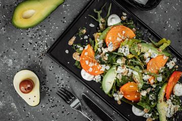 Fresh salad with fruits and greens on dark canvas background. Healthy food