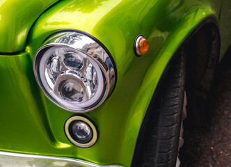 Retro car festival. Retro car headlight. Fragment of the front of a retro car.