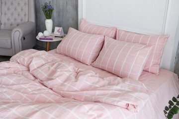 Pink ecologycal linen on bed in modern home interior. Daylight