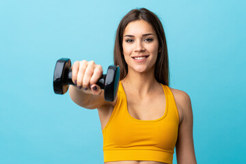 Young caucasian woman making weightlifting isolated on blue background