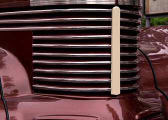 Retro car festival. Radiator grille of an old restored car. Fragment of the front of a retro car.