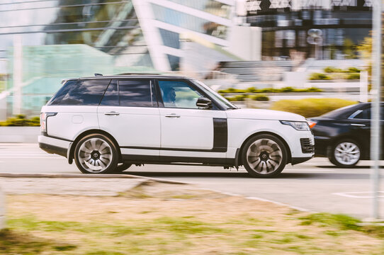 White Range Rover L405 car moving on the street on high speed. Fast moving luxury SUV car on the highway road.