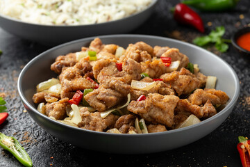 Stir fry chinese salt and pepper chicken with rice in grey bowl