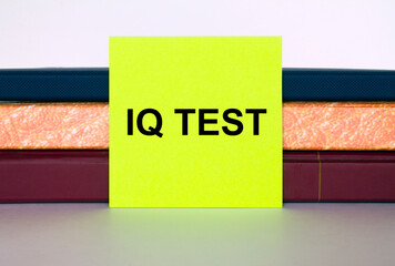 Yellow sticker with text Iq Test on a stack of notebooks - obrazy, fototapety, plakaty
