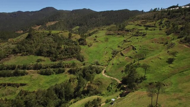 Aerial forward over green mountains of El Castillo village near Constanza, Dominican Republic