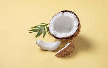 fresh coconut and slices  on yellow  background. Healthy and vegan food. Copy space