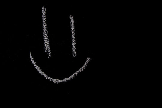 A close up of a smiling face on a chalk board
