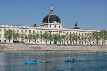 Fototapeta na wymiar deux canoés sur le Rhône à lyon devant l'hôtel Dieu